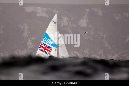 Iain Percy et Andrew Simpson, marins des étoiles de Grande-Bretagne, cachés par la houle qui se déroule dans la baie de Weymouth lors de la septième course de leur série olympique au large de Weymouth aujourd'hui. Banque D'Images