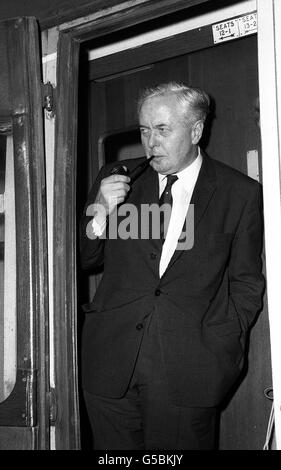 Dans la posture non chalente d'un homme qui sent que son avenir est assuré, M. arold Wilson fume castiquement son tuyau dans la porte de la calèche avant de quitter la gare d'Euston pour une brève visite à son huyton Lancashire, costituence. Banque D'Images