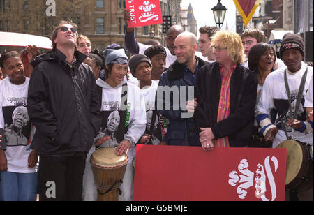 La chanteuse Beverley Knight, deuxième à droite, et les membres du groupe rock REM, Michael Stipe, tête rasée, et Mike Mills, chemise rayée et Peter Buck, à gauche, à Trafalgar Square avec 36 jeunes musiciens de Grande-Bretagne et d'Afrique du Sud. * ils où ils se feront au concert de la Journée de la liberté de la confiance du Prince. Banque D'Images