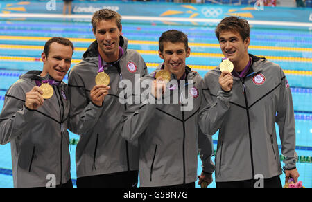 L'équipe Medley Relay des États-Unis (de gauche à droite) Brendan Hansen, Matthew Grevers, Michael Phelps et Nathan Adrian célèbrent avec leurs médailles d'or au Aquatic Center. Banque D'Images