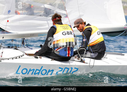 Iain Percy (à droite) et Andrew Simpson, en Grande-Bretagne, réagissent après avoir remporté la médaille d'argent alors qu'ils étaient en position de médaille d'or pendant la nuit dans la course de médaille d'étoile masculine à Weymouth. Banque D'Images