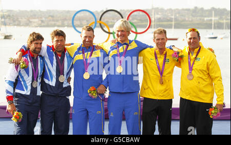 Fredrik LOOF et Max Salminen, les marins suédois de la classe Star, célèbrent leur médaille d'or olympique, flanquée par Iain Percy et Andrew Simpson, qui ont gagné l'argent (à gauche), et Robert Scheidt et Bruno Prada, du Brésil, qui ont gagné le bronze. Banque D'Images