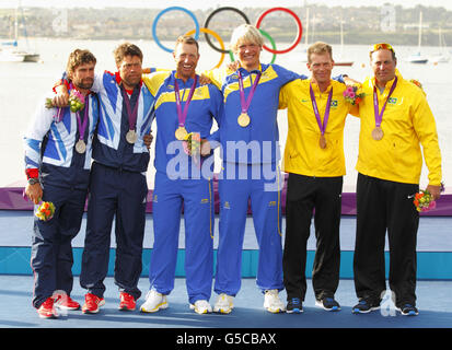 Fredrik LOOF et Max Salminen, les marins suédois de la classe Star, célèbrent leur médaille d'or olympique, flanquée par Iain Percy et Andrew Simpson, qui ont gagné l'argent (à gauche), et Robert Scheidt et Bruno Prada, du Brésil, qui ont gagné le bronze. Banque D'Images