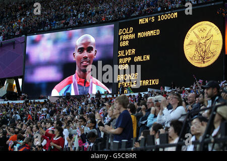 Mo Farah, en Grande-Bretagne, sur les grands écrans autour du stade olympique, reçoit la médaille d'or pour avoir remporté les 10,000 mètres masculin au stade olympique de Londres. Banque D'Images