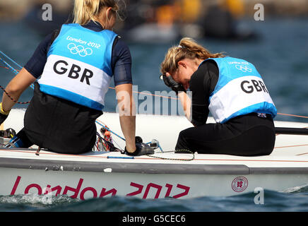 Hannah Mills, à la barre de 470, a remporté la médaille d'argent des femmes de Grande-Bretagne, avec l'équipage Saskia Clark (à gauche), qui tient la tête dans la main après avoir pris la fuite derrière les médailles d'or de Nouvelle-Zélande à la régate olympique de Weymouth aujourd'hui Banque D'Images