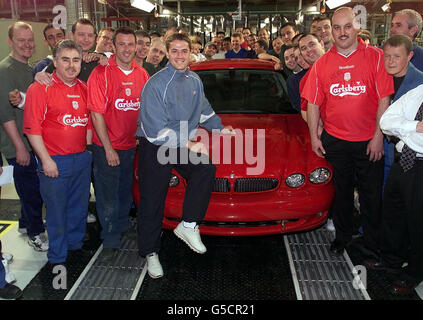 Michael Owen, footballeur de Liverpool et d'Angleterre, est assis sur une nouvelle Jaguar X-Type, surnommée le « bébé JAG », avec des travailleurs à l'usine Jaguar de Halewood, à Merseyside. Le constructeur automobile de luxe a pris des commandes avancées d'une valeur d'environ 100 millions pour son nouveau modèle. * ...qui sera en vente le 23 2001 mai, la X-type est la première entrée de Jaguar sur le marché des voitures de luxe junior Executive. Banque D'Images