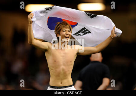 Le sung yueng Ki de Corée du Sud célèbre avec le drapeau de son pays Après son match de camp, le Japon a gagné le football masculin Médaille de bronze au Millennium Stadium Banque D'Images