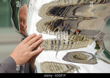 Le sculpteur Tony Cragg se reflète dans sa sculpture 'Elliptical Column 2012', qui fait partie de 'Tony Cragg at Exhibition Road', qui est la première exposition de sculpture le long de la nouvelle section piétonne de Exhibition Road, à Kensington, à l'ouest de Londres. Banque D'Images