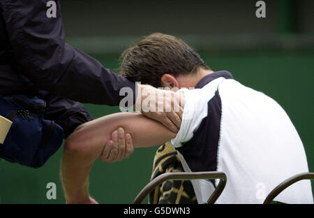 PAS D'USAGE COMMERCIAL : Goran Ivanisevic de Croatie a un peu de traitement sur son bras lors de son match contre Pat Rafter en Australie lors de la finale des hommes des Championnats de tennis de pelouse 2001 à Wimbledon à Londres. Banque D'Images