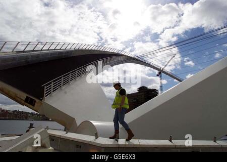 Pour la première fois, un ouvrier vérifie le Millennium Eye Bridge de Newcastle. Le 22 millions de Gateshead Millennium Bridge, conçu pour s'ouvrir dans un mouvement d'yeux « clignotant », a attiré la publicité mondiale quand il a été assemblé sur Tyneside. * il a été construit dans un chantier naval puis transporté sur une barge géante pour être soulevé en place près du pont historique de Tyne. Depuis que le pont en acier de 850 tonnes a été mis en place sur la rivière Tyne par l'une des plus grandes grues flottantes au monde en novembre dernier, les grands bateaux n'ont pas pu passer en dessous. Banque D'Images