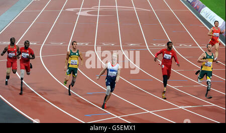 Jonnie Peacock (4ème à gauche), de Grande-Bretagne, franchit la ligne pour remporter la finale hommes-femmes de 100 m, lors des Jeux paralympiques de Londres. Banque D'Images