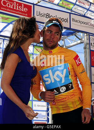 Mark Cavendish de Team Sky met sur le maillot jaune du leader général de course après sa victoire dans la quatrième étape du Tour de Britan de Carlisle à Blackpool. Banque D'Images