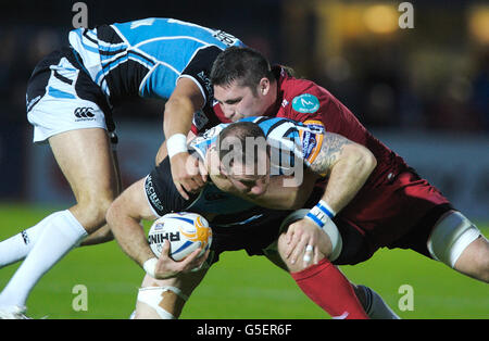 Rugby Union - RaboDirect PRO12 - Glasgow Warriors v Scarlets - Scotstin Stadium.Graeme Morrison (centre) des Glasgow Warriors est abordé Banque D'Images