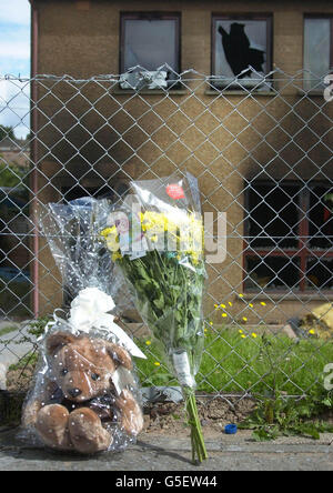 Un ours en peluche et un bouquet de fleurs laissé par deux jeunes résidents locaux se trouvent à l'extérieur de la scène d'un incendie à Perth, où cinq occupants sont morts. Une fille de deux ans et un garçon de huit ans sont morts aux côtés de leurs grands-parents. * , mais la mère du garçon et son frère ont réussi à s'échapper de la maison à Birnham Crescent sur le domaine de Letham. Le fiancé de 26 ans de la mère est également mort dans l'incendie. Banque D'Images