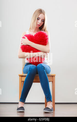 Broken Heart Love concept. Triste Malheureux woman hugging coeur rouge Banque D'Images