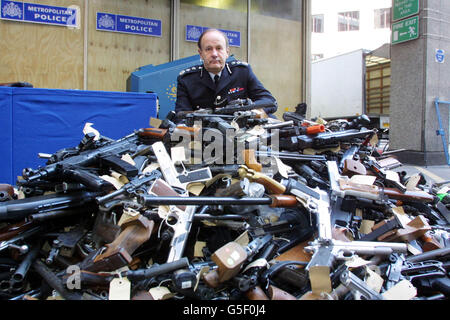 Sir John Stevens, commissaire de police métropolitaine, lors d’un appel photo à Scotland Yard à Londres, pour montrer les armes récupérées par la police, avant qu’elles ne soient détruites en les mettant dans une déchiqueteuse métallique qui les écrase et les écrase en petits morceaux. * la police dit que leurs opérations saisissent en moyenne 600 armes à feu par an, y compris Uzis, fusils de chasse et pistolets. Banque D'Images