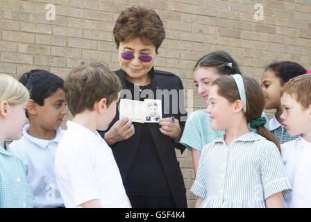 Le musicien et artiste Yoko Ono, veuve de John Lennon, chanteur des Beatles, montre une photo de son défunt mari aux enfants de l'école Dovedale à Liverpool.Elle a visité l'école à laquelle assistait son défunt mari alors qu'il était jeune à Liverpool. Banque D'Images