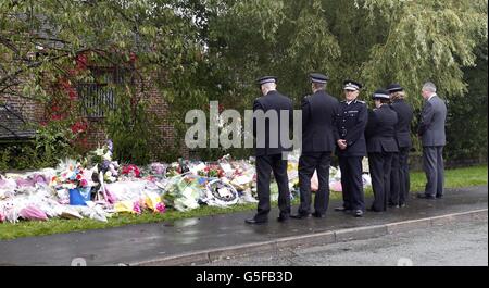Sir Peter Fahy, chef du Grand Manchester (troisième à gauche), s'arrête un moment avec d'autres officiers, après avoir déposé des fleurs près de la scène où les PCS Fiona Bone et Nicola Hughes ont été tués à Hattersley, Tameside. Banque D'Images