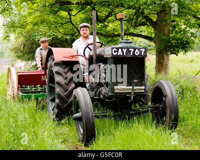 Agriculteur et farm boy en 1940, l'habillement avec début Fordson tracteur et semoir. NB c'est un re-enactment. Banque D'Images