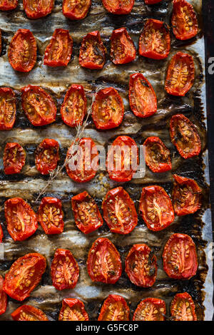 Tomates séchées - Alimentation et boisson des tomates séchées avec du thym, sel de mer et d'huile d'olive sur un plateau Banque D'Images