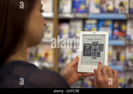 Lucy Harvey détient un lecteur électronique Kobo alors que WHSmith lance le Wi-Fi client gratuit avec le Cloud, à Westfield London, à Shepherds Bush, permettant aux acheteurs de télécharger des livres électroniques en magasin. Banque D'Images