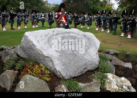 Un groupe de tuyaux se trouve derrière le Ballater Jubilee Cairn, à Ballater, dans l'Aberdeenshire, alors que la reine Elizabeth II a officiellement dévoilé une plaque marquant un cairn spécial du Jubilé de diamant près de son domaine Balmoral. Banque D'Images