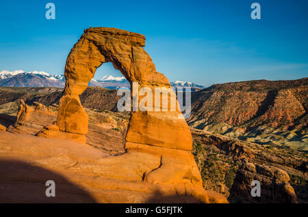 Montagne enneigée en arrière-plan sous une arche dans le parc national d'Arches dans l'Utah merveilleux, au printemps. Nature et zone touristique étonnantes Banque D'Images