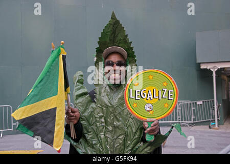 Un homme à Times Square vêtue comme une feuille de marijuana jamaïcaine de drapeaux et d'un holding pot légaliser signe. Dans la ville de New York. Banque D'Images