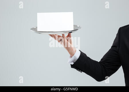 Part of waiter holding tray en costume noir avec carte vierge Banque D'Images