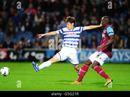 Soccer - Barclays Premier League - Queens Park Rangers v West Ham United - Loftus Road.Guy Demel (à droite) de West Ham United et Ji-Sung Park (à gauche) des Queens Park Rangers se battent pour le ballon Banque D'Images