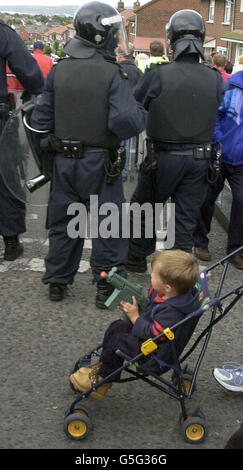 Un jeune en fauteuil roulant porte une arme à jouets tout en étant poussé à travers les manifestants protestants, ainsi que les élèves de l'école Sainte-Croix.* les Loyalistes ont sifflé et crié des abus à l'encontre des parents d'enfants de l'école primaire de Sainte-Croix dans le nord de Belfast, en raison d'avertissements, la manifestation pourrait durer indéfiniment à moins que des pourparlers ne soient en cours pour tenter de mettre fin à la stand-off. Banque D'Images
