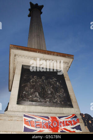 Un drapeau est placé sur la colonne de Nelson pendant que les gens manifestent au sujet du bombardement de l'Afghanistan par les États-Unis et le Royaume-Uni à Trafalgar Square, Londres sur leur chemin vers Downing Street. Les récents attentats à la bombe en Afghanistan font suite aux attaques terroristes contre les États-Unis le mois dernier. Banque D'Images