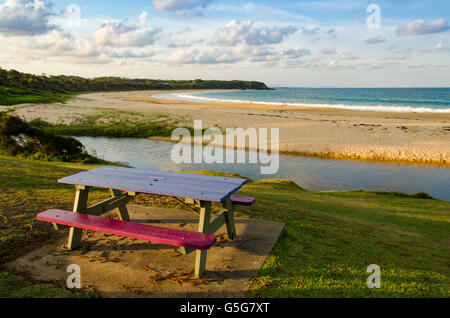 Un banc de parc donne sur une plage de la côte nord de la Nouvelle-Galles du Sud en Australie mi Banque D'Images