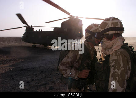 Royal Marine Commandos en exercice dans le désert d'Oman, une partie de SAIF SAREEA 2, un exercice impliquant des forces communes.Les Marines du 45 Commando attendent sur une colline alors qu'un Chinook de la RAF arrive pour apporter des approvisionnements. Banque D'Images