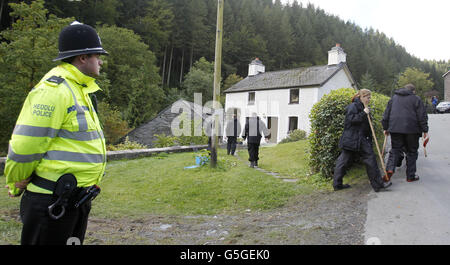 Des policiers gallois foutent devant une maison du nom de Mount Pleasant dans le village de Ceinws, considéré comme la dernière résidence de Mark Bridger, suspect dans l'enlèvement d'avril Jones. Banque D'Images