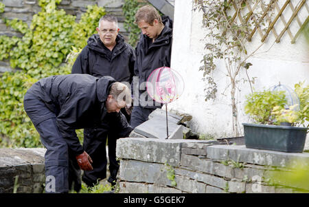 Des policiers gallois foutent devant une maison du nom de Mount Pleasant dans le village de Ceinws, considéré comme la dernière résidence de Mark Bridger, suspect dans l'enlèvement d'avril Jones. Banque D'Images