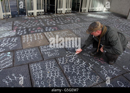 Dire NON aux manifestants de l'OTAN s'attirent sur le trottoir devant les portes du Parlement écossais d'Édimbourg. Banque D'Images