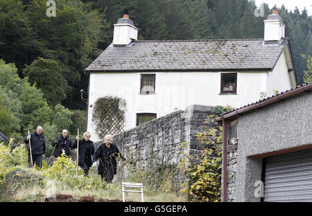 Les policiers foutent devant une maison appelée 'Mute Pleasant' dans le village de Ceinws, qui était la dernière résidence connue de Mark Bridger, le suspect dans l'enlèvement d'avril Jones. Banque D'Images