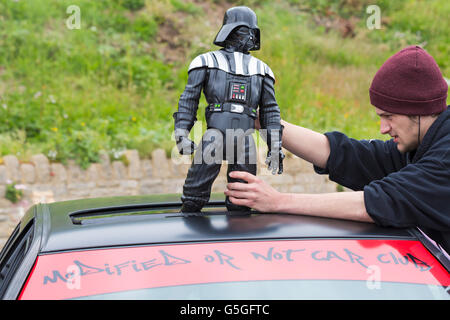 Jeune homme avec Darth Vader, figure sur le dessus de la voiture, modifié ou non car club, à l'affiche au festival en juin Roues Bournemouth Banque D'Images