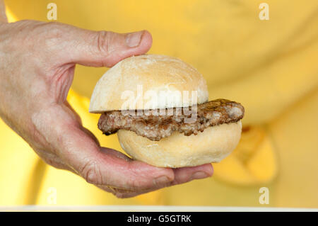 L'Italie, Lombardie, Street Food, main d'un chef Holding une saucisse Banque D'Images