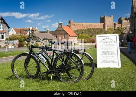 Royaume-uni, Angleterre, Bamburgh Northumberland village, des vélos sur le vert avec château au-delà Banque D'Images