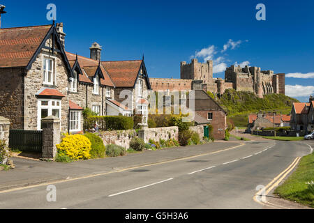 Royaume-uni, Angleterre, Bamburgh Northumberland, village estate maisons dans la rue de l'Église avec château au-delà Banque D'Images