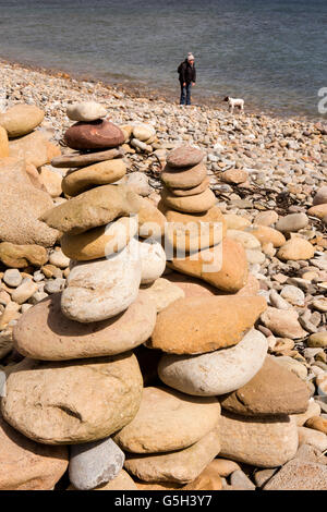 Royaume-uni, Angleterre Northumberland, Holy Island, Lindisfarne Castle Point, plage de cairns et galets walker avec chien Banque D'Images