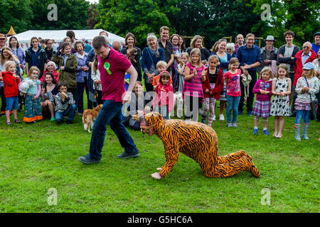 Un homme habillé en costume de tigre prend part à une exposition canine, Kingston Fête du Village, Lewes, dans le Sussex, UK Banque D'Images