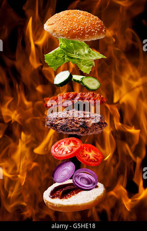 Gros barbecue bacon burger on fire flame grill background Banque D'Images