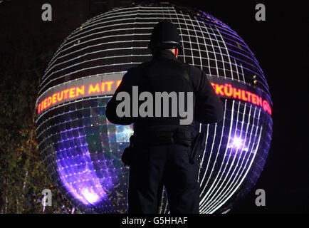 Un policier se tient devant un ballon miroir géant Smirnoff, actuellement le plus grand ballon miroir suspendu au monde, situé à l'extrémité sud du Millennium Bridge sur la rive sud de Londres, Le spectacle visuel marque les horloges qui reviennent ce week-end et appelle la Grande-Bretagne à profiter au maximum de son heure supplémentaire. Banque D'Images