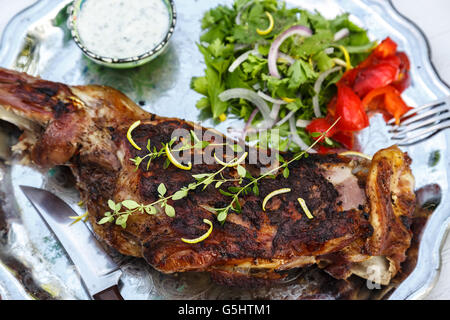 Épaule d'agneau rôti aux herbes sur une plaque Banque D'Images