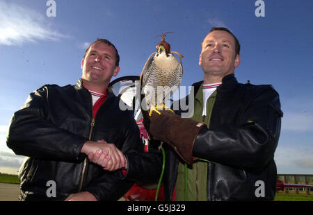 Le chef d'escadron Carl 'brochet' Jepson (R) prend la barre des flèches rouges du commandant d'escadre Andy Offer sous les yeux vigilants d'un faucon de la RAF Scampton, Lincolnshire.* Sqn LDR Jepson deviendra le 16e leader des flèches rouges depuis la création de l'équipe en 1965.Il a récemment été au Moyen-Orient en train de se convertir à l'avion Hawk de son Harrier habituel et a pris le contrôle de l'équipe dès qu'il a remis le pied sur le sol britannique. Banque D'Images