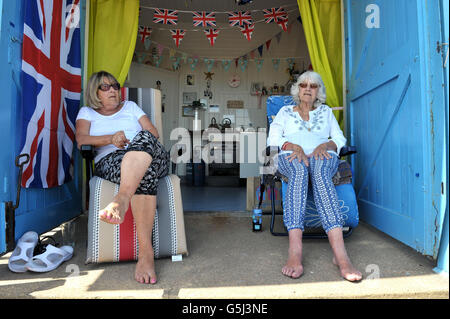 Christine Gooderham (à gauche) et sa sœur Susan Whitlock, tous deux de Clacton, vous détendre dans leur famille beach hut comme ils profiter du beau temps à Clacton-on-Sea dans l'Essex. Banque D'Images