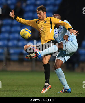 William Edjanguele de Coventry City et Chris Dillon de Arlesey Town lors du match de la première ronde de la coupe FA à la Ricoh Arena, Coventry. Banque D'Images